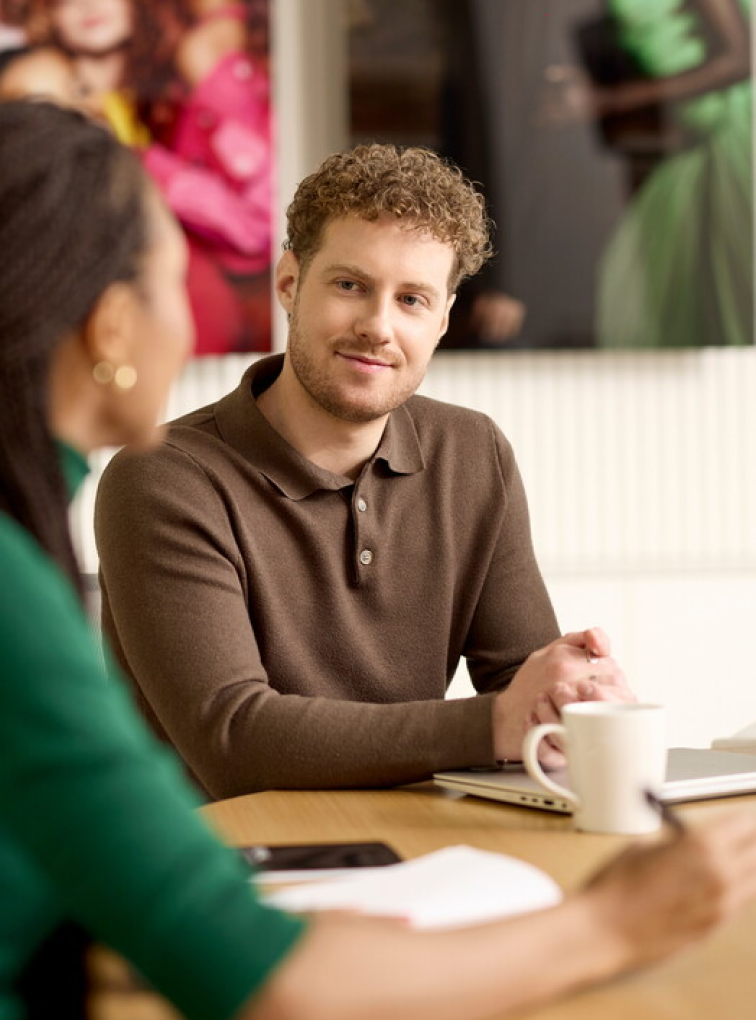 Two colleagues talking at a table indoors