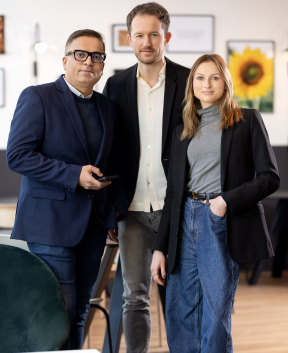 Three colleagues posing together in office