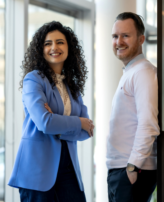 Two people standing side by side in office