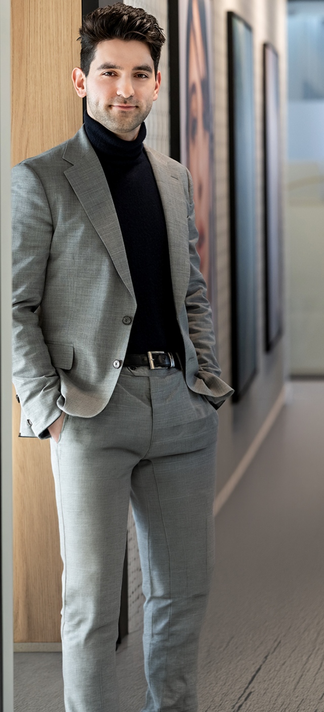 Person in blazer standing in office hallway