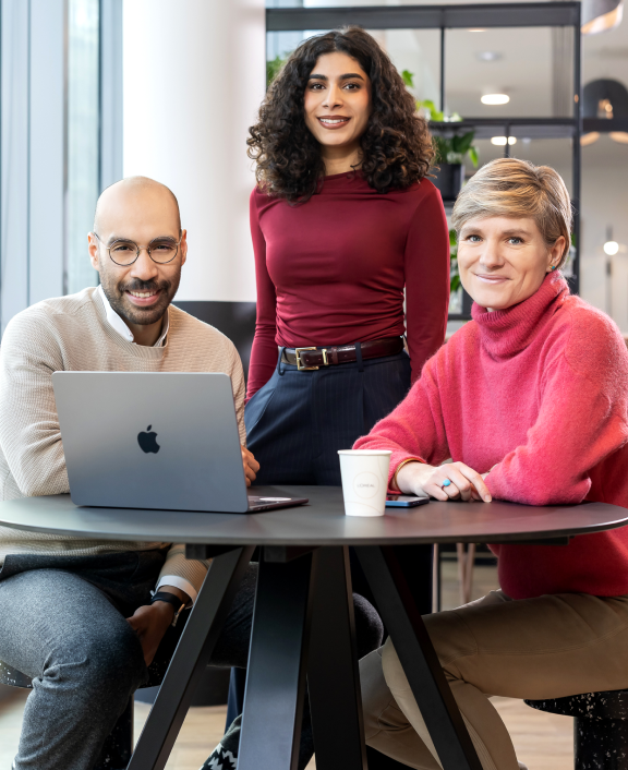 Three colleagues discussing ideas around table