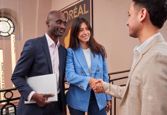 Three coworkers shaking hands in an office space