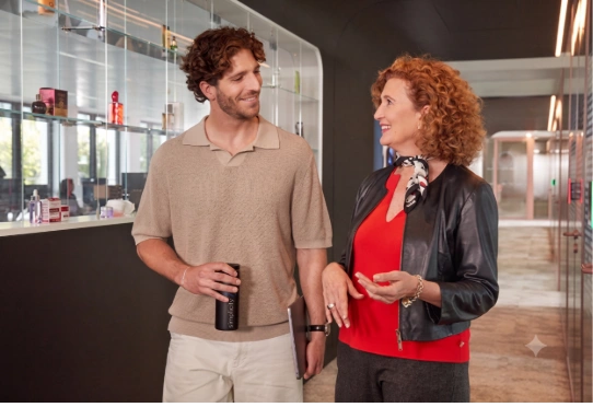 Two people walking and talking in office hallway