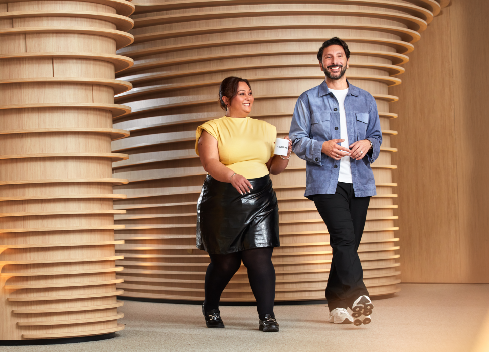 Two people walking and smiling indoors