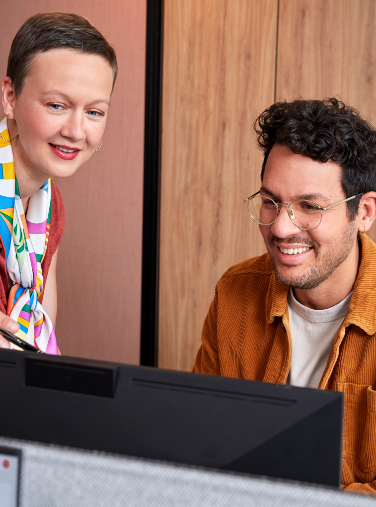 Two colleagues reviewing work on desktop