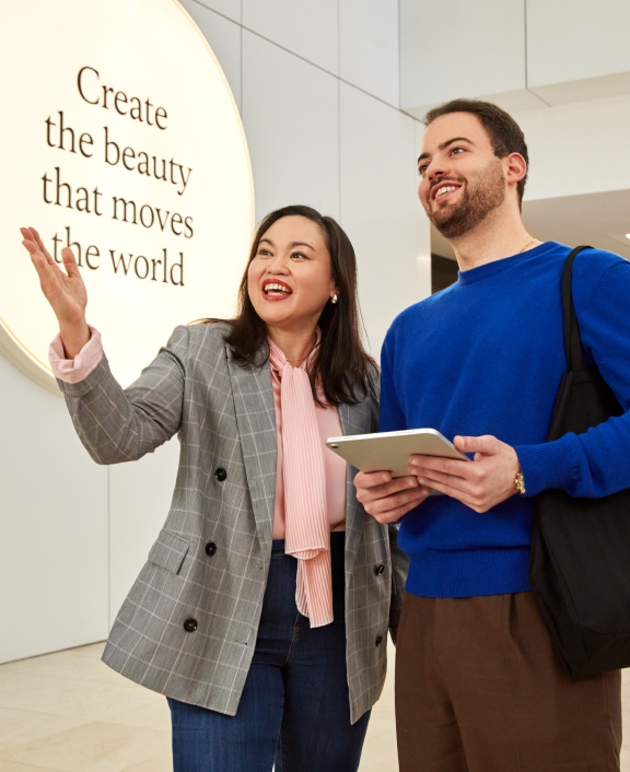 Two people discussing near inspirational wall sign