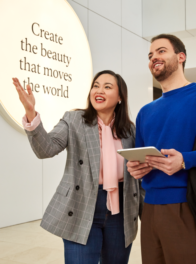 Two people discussing near inspirational wall sign
