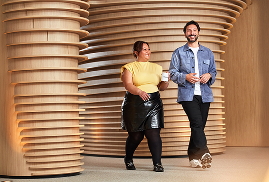 Two people walking and smiling indoors