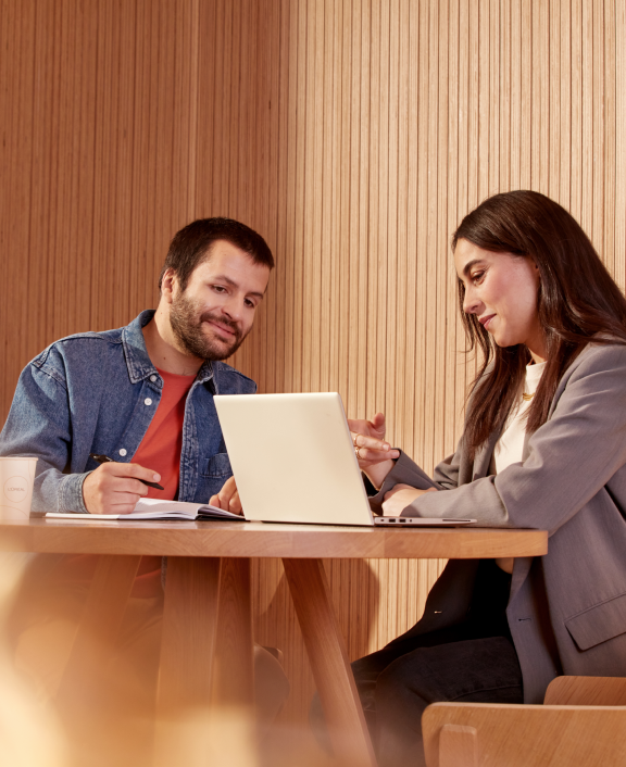 Two colleagues reviewing work on laptop together