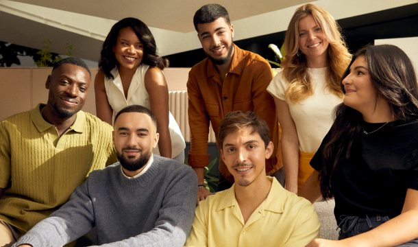 Six coworkers posing together indoors scene nicely