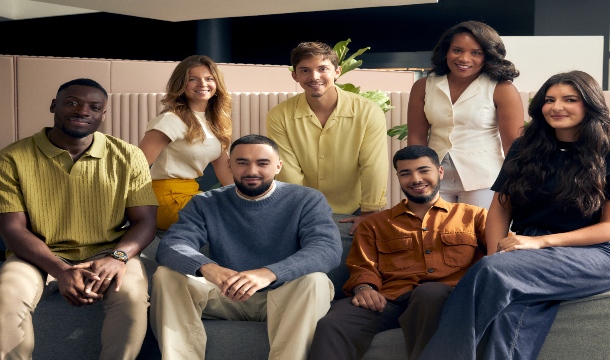 Six coworkers posing together indoors scene nicely