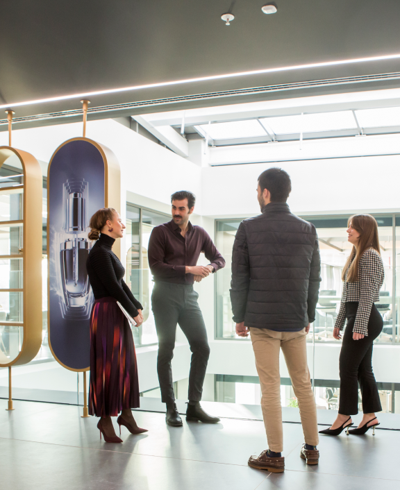Quatre personnes discutant d’idées dans un bureau moderne.