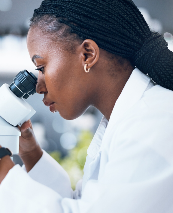 Scientist using microscope in lab setting closeups