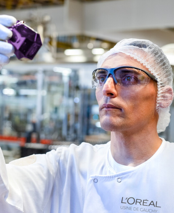 Technicien examine flacon violet en laboratoire