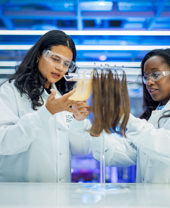 Two lab workers examining hair samples in lab
