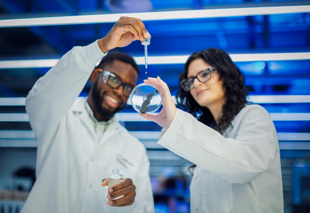 Two lab workers testing sample with dropper