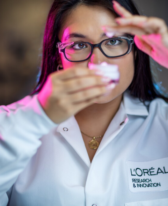 Lab worker holding sample and examining it closely