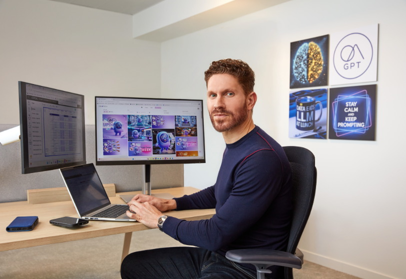 Person working at desk with AI tools and screens