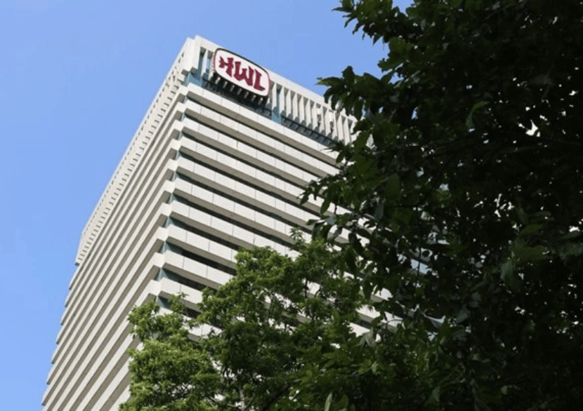 Hoog kantoorgebouw met logo en bomen
