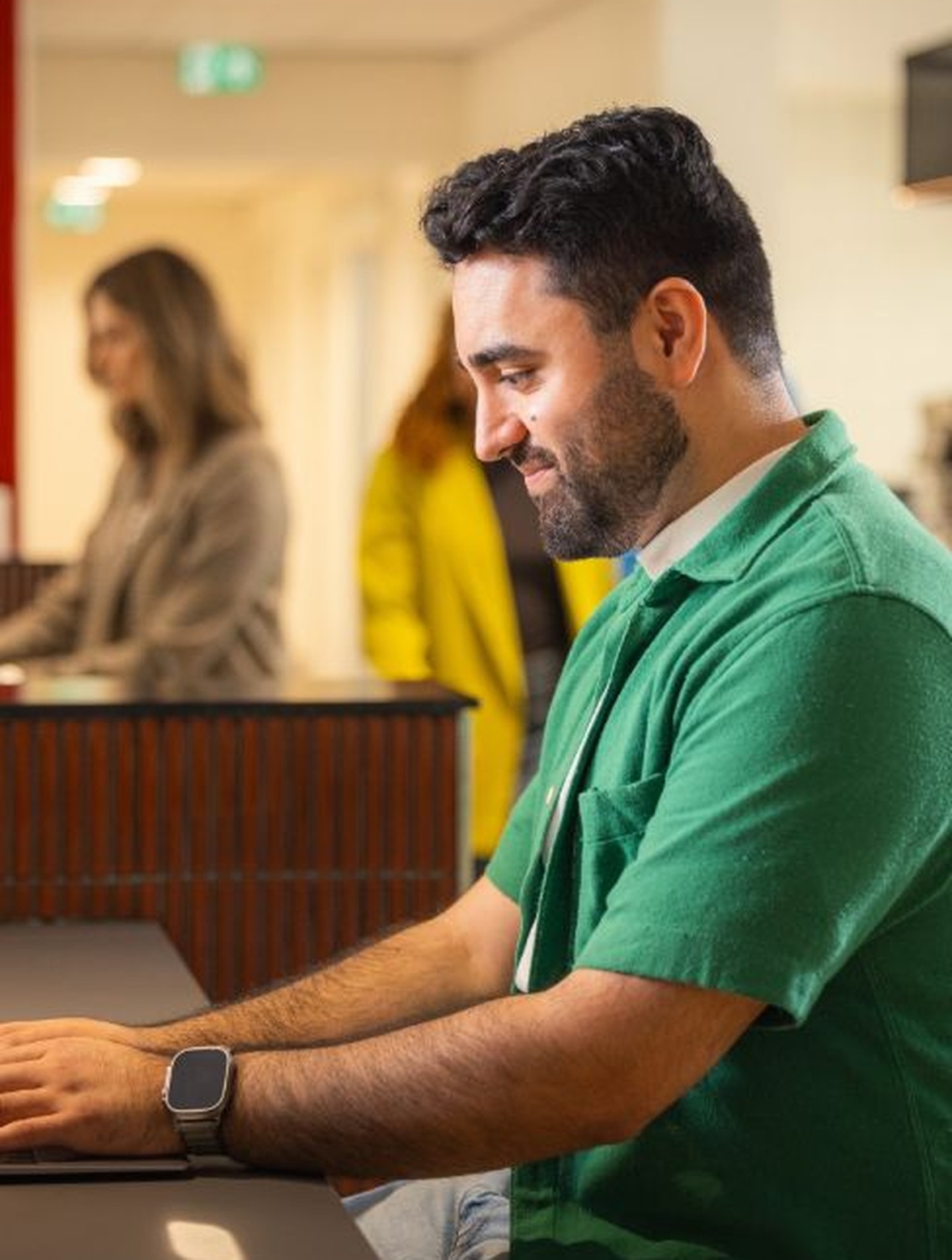 Persoon gebruikt laptop aan een balie binnenshuis