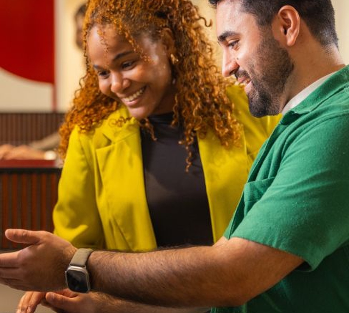 Twee mensen kijken samen naar een telefoon binnenshuis