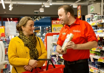 Medewerker helpt klant met product in winkel