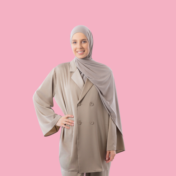 Persoon in beige outfit met hoofddoek