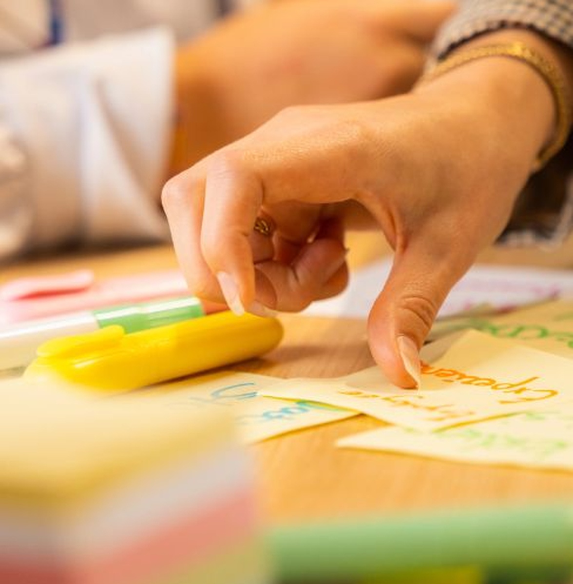Hand plaatst een notitie met markeerstift op een bureau