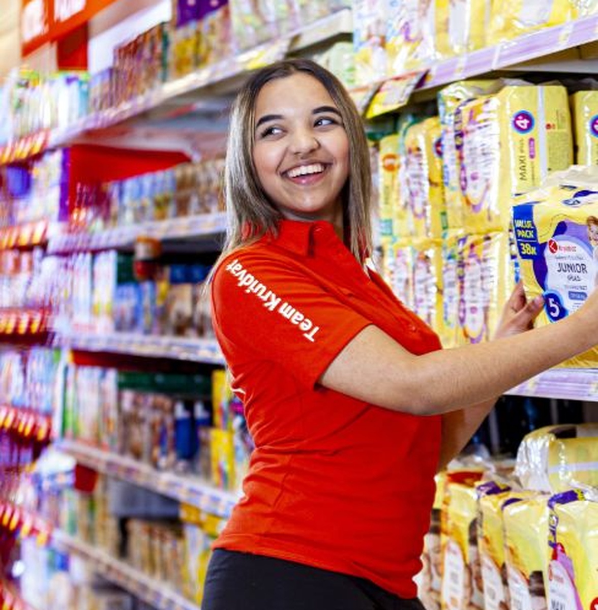 Winkelmedewerker vult schappen in supermarkt