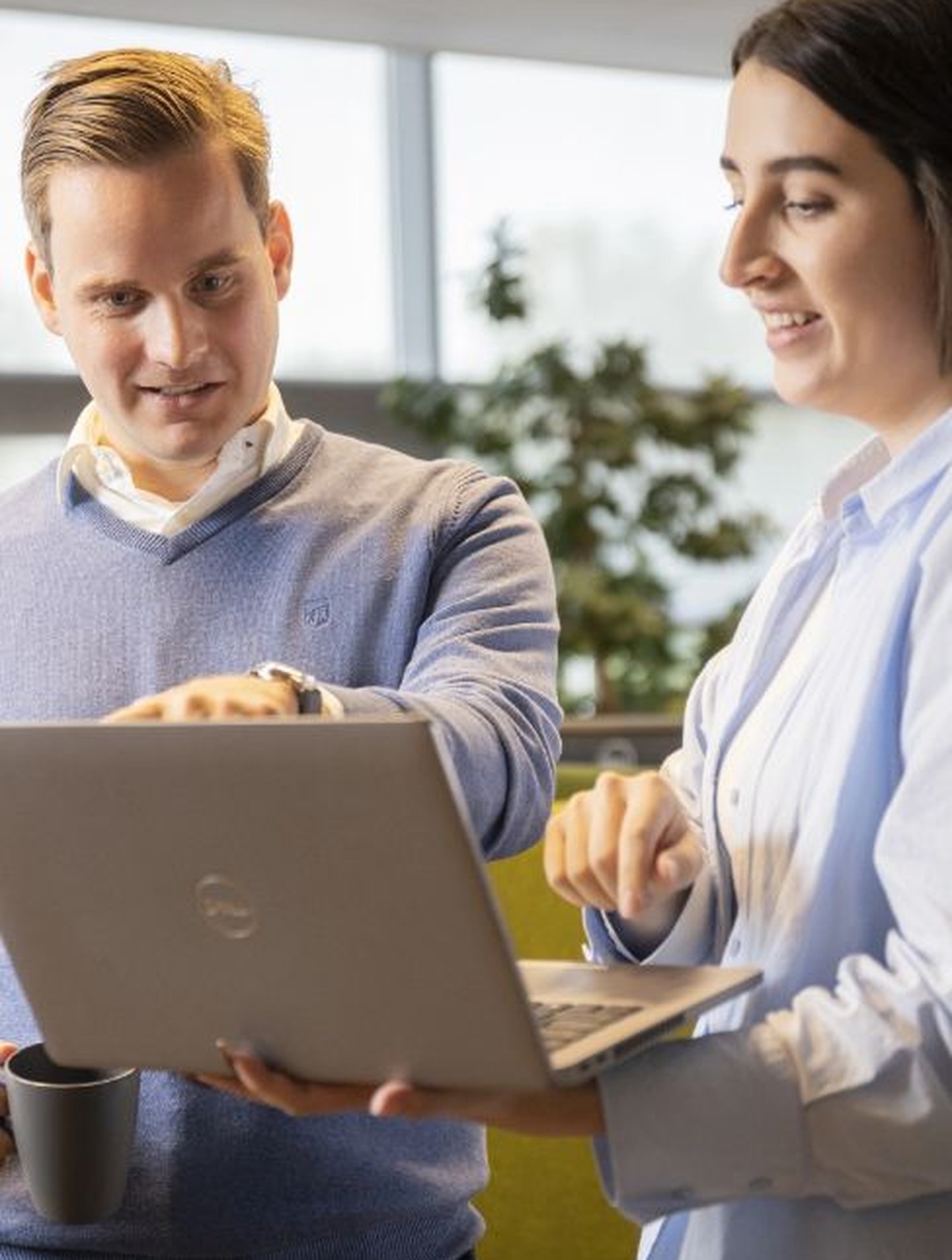 Twee collega’s bekijken laptop en wijzen naar scherm