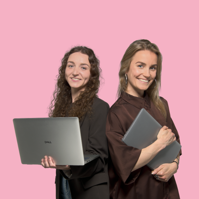 Twee personen poseren samen voor een roze achtergrond.