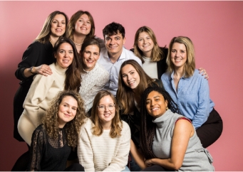 Groep mensen poseren voor foto op roze achtergrond