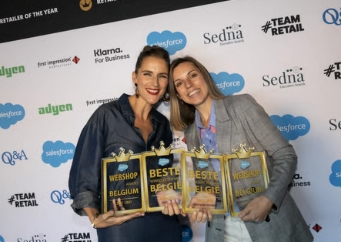 Twee personen met awards bij event backdrop