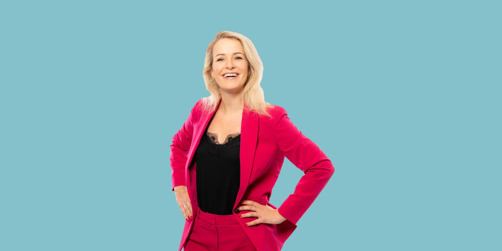 Vrouw in roze pak met handen op heupen