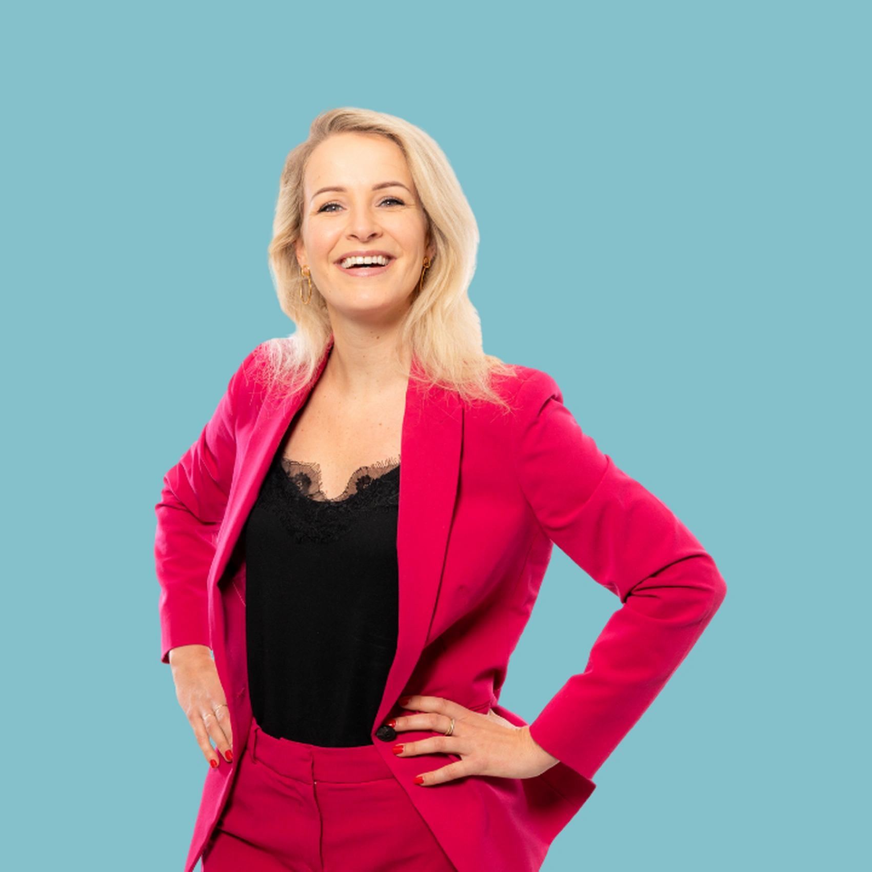 Vrouw in roze pak met handen op heupen