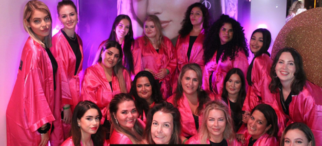 Groep mensen in roze jassen tijdens een evenement.