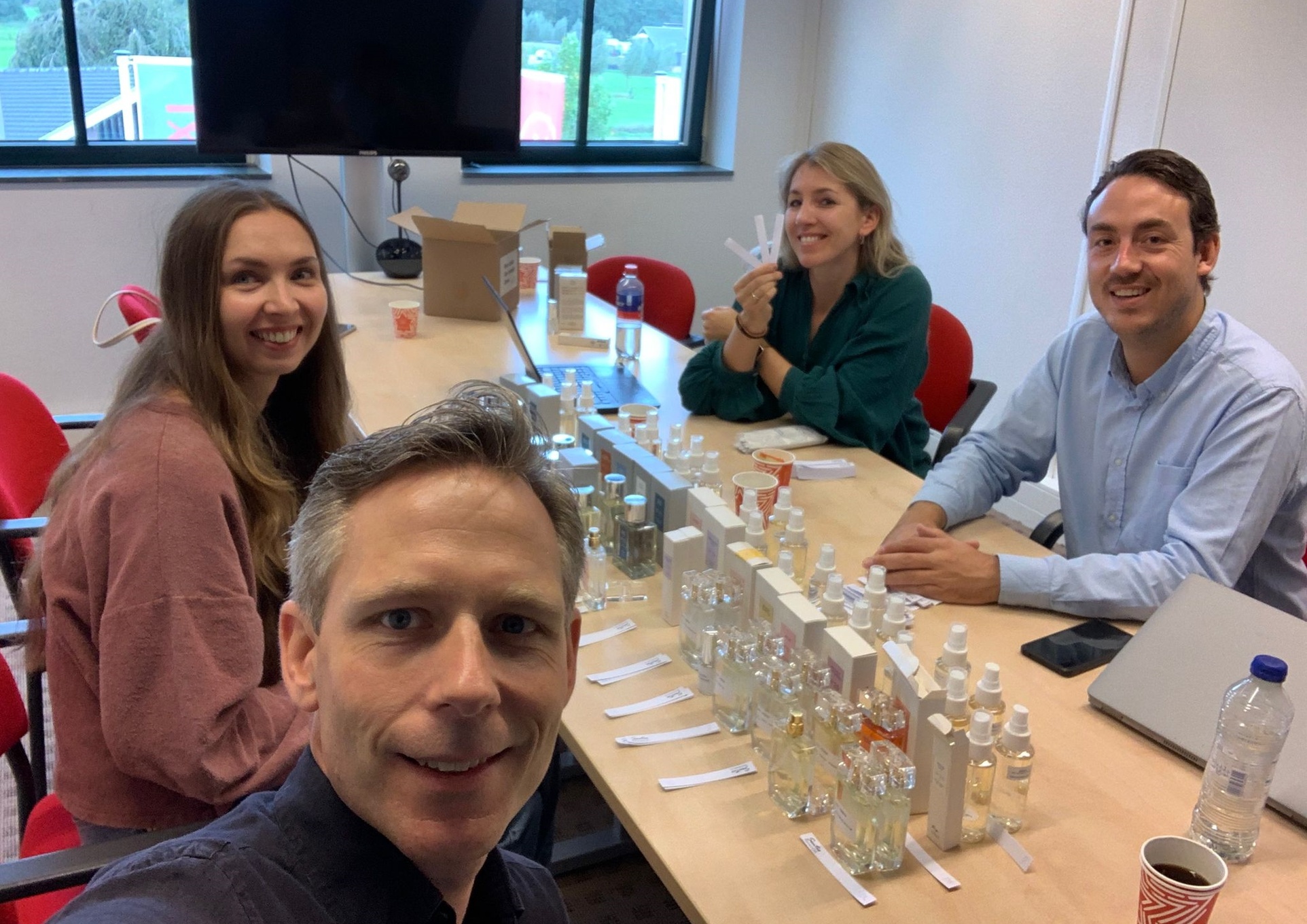 Groep rond tafel met parfumtesten