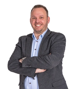 Persoon met armen gekruist glimlacht