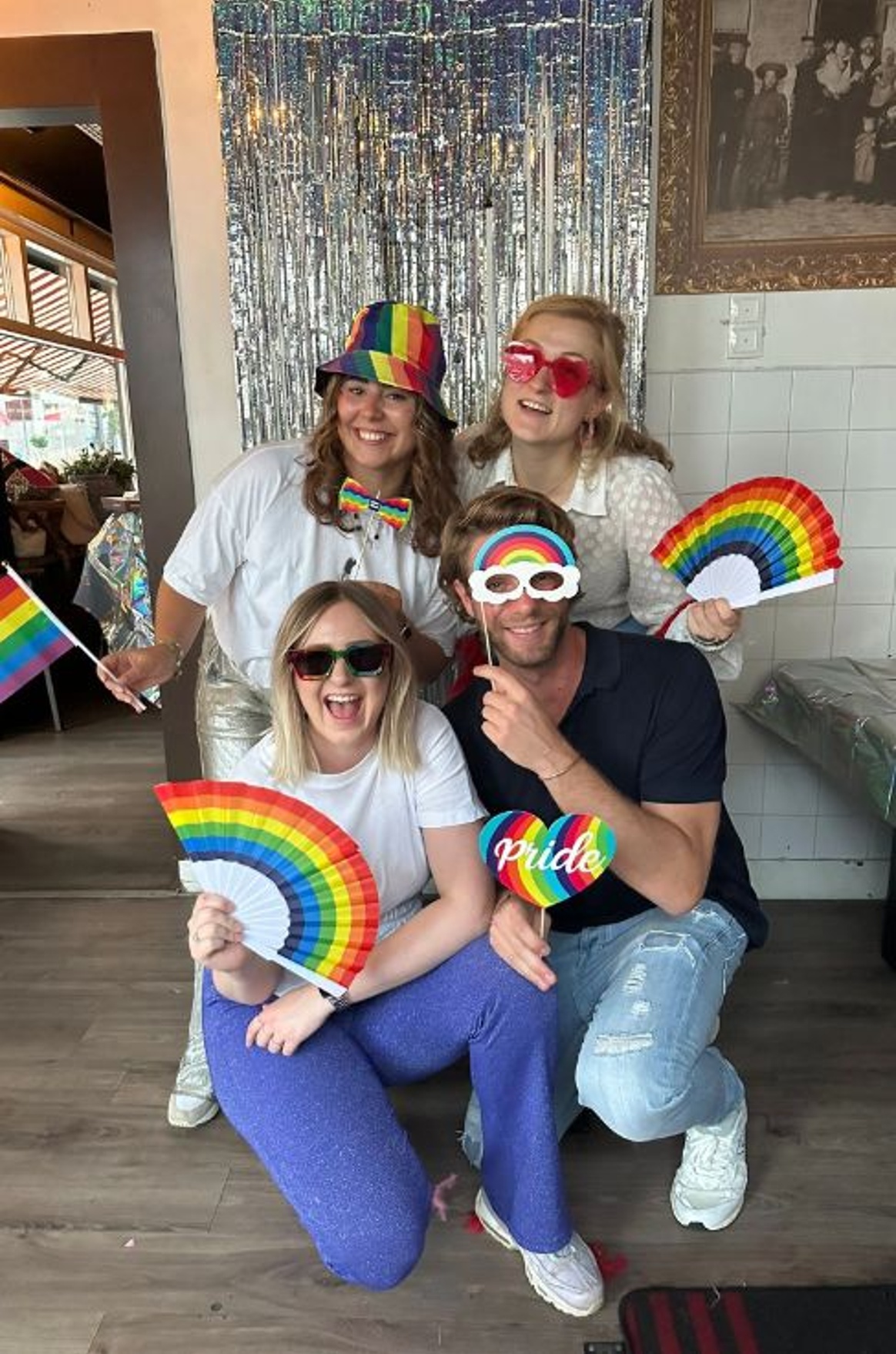 Vier personen met regenboogaccessoires bij Pride feest