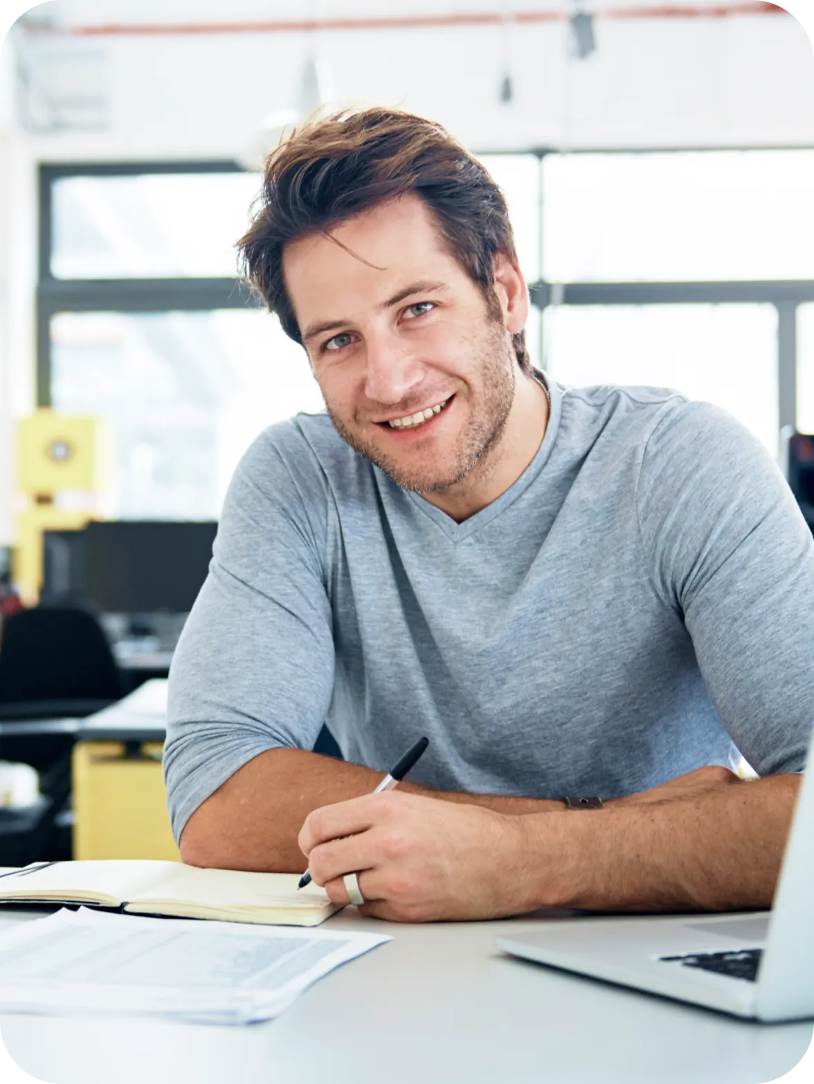 Professional working at desk with notebook and laptop