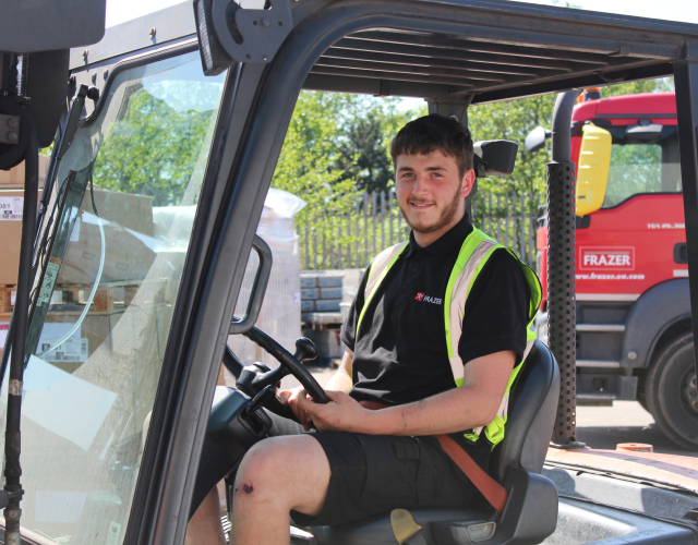 Warehouse worker in forklift at delivery yard