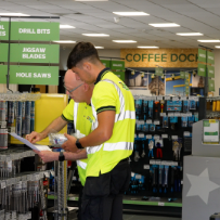 Staff reviewing inventory list in hardware store