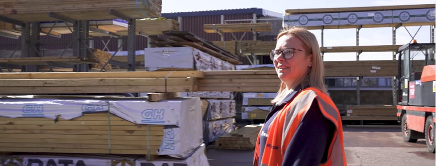 Woman in safety vest at timber yard