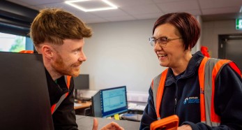 Person in safety vest working at computer