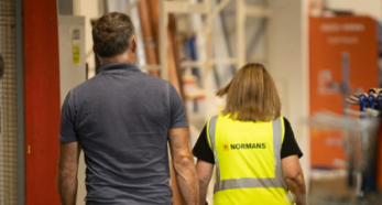 Two people walking through hardware store aisle￼