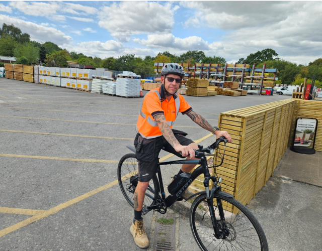 Employee cycling through builders merchant yard site