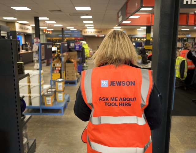 Two people viewing tools on warehouse shelving rack