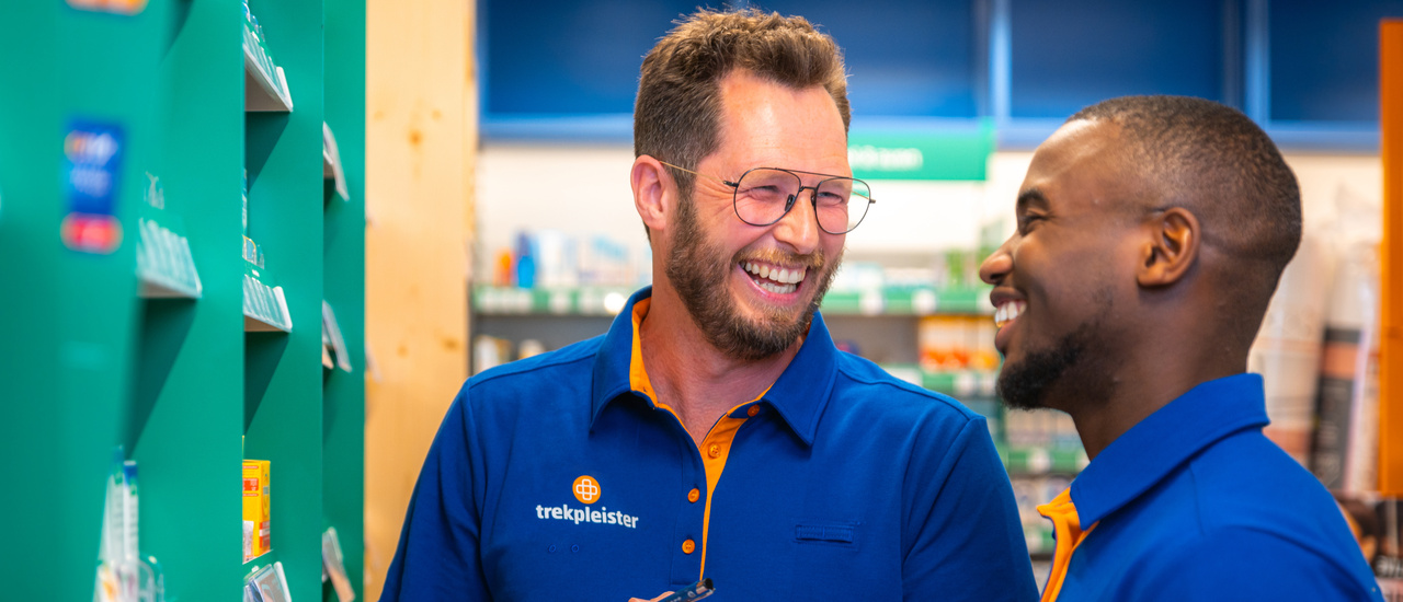 Twee winkelmedewerkers in gesprek tussen de schappen
