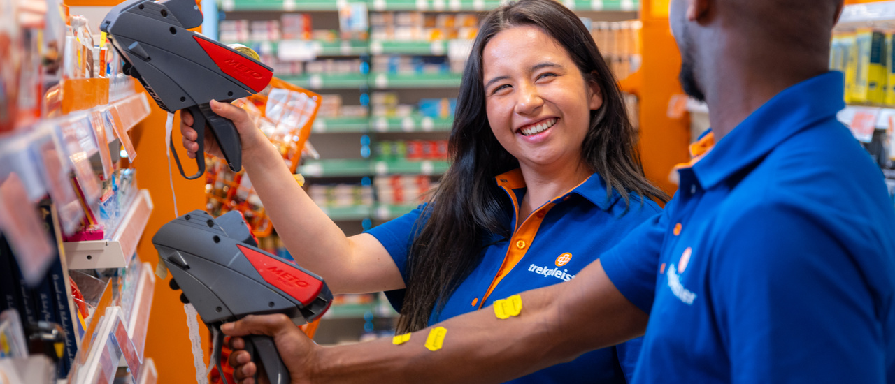 Vrouw die babyproducten in een winkelschap in een gangpad plaatst.