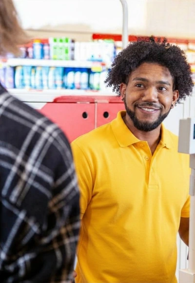 Persoon betaalt en geeft kaart aan medewerker shop
